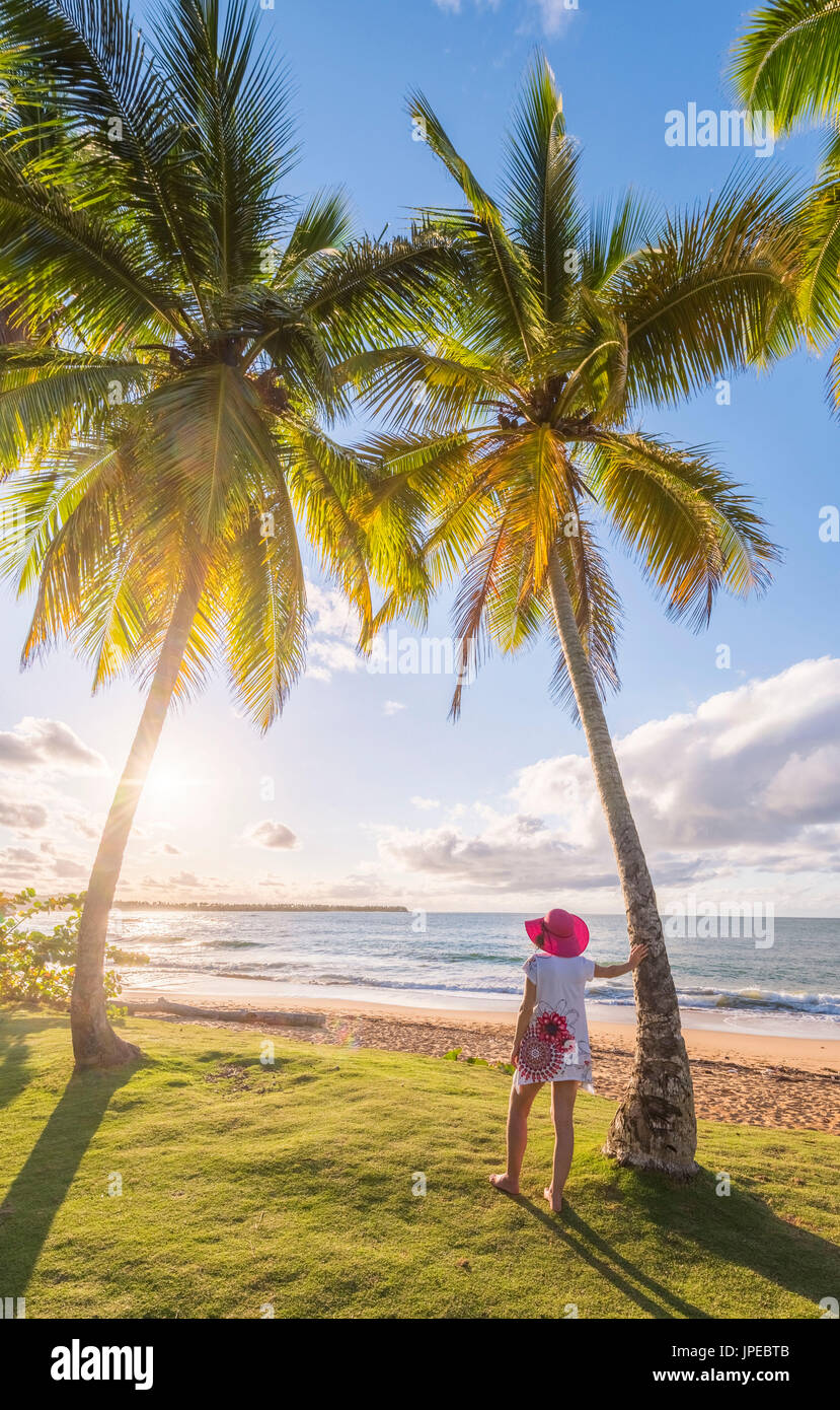Playa Moron, Las Terrenas, Halbinsel Samaná, Dominikanische Republik. Entspannen Sie sich auf eine Palmen gesäumten Wiese (MR) Frau. Stockfoto