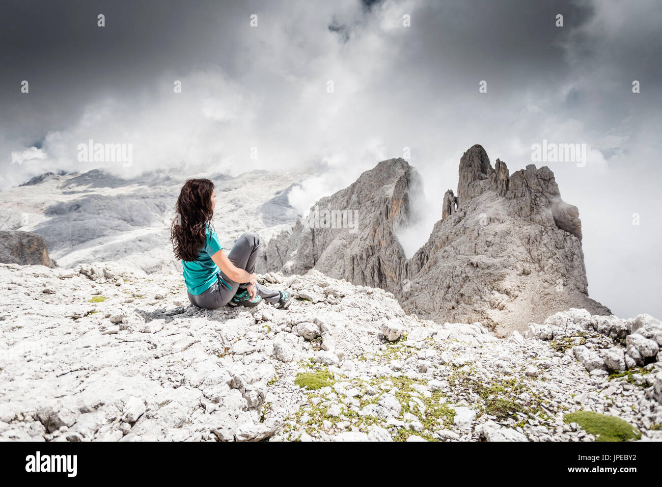 eine Momentaufnahme von einem Wanderer sitzen auf den Felsen und der Pala-Gruppe auf Berggipfel, Provinz Trento, Trentino Alto Adige, Italien, Europa Stockfoto