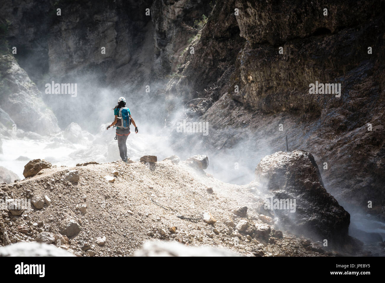 eine Momentaufnahme von einem Wanderer zu Fuß durch eine Wolke von Wasser durch die Kraft des Wasserfalls, Belluno Provinz, Venetien, Italien, Europa Stockfoto