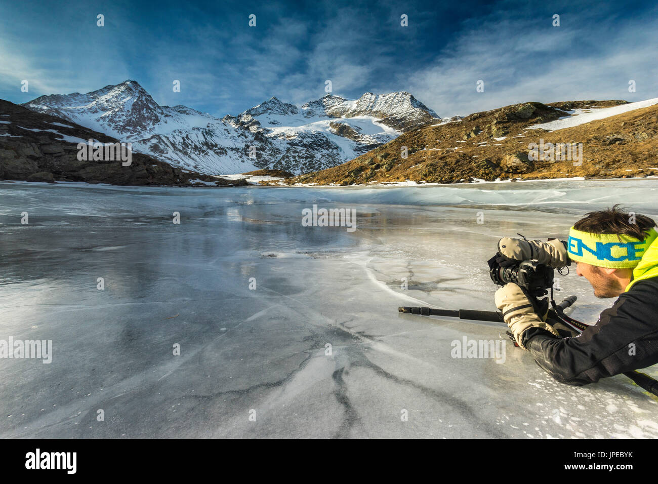 Berninapass, Schweiz. Ein Fotograf in Aktion auf einem Fronzen See. Stockfoto