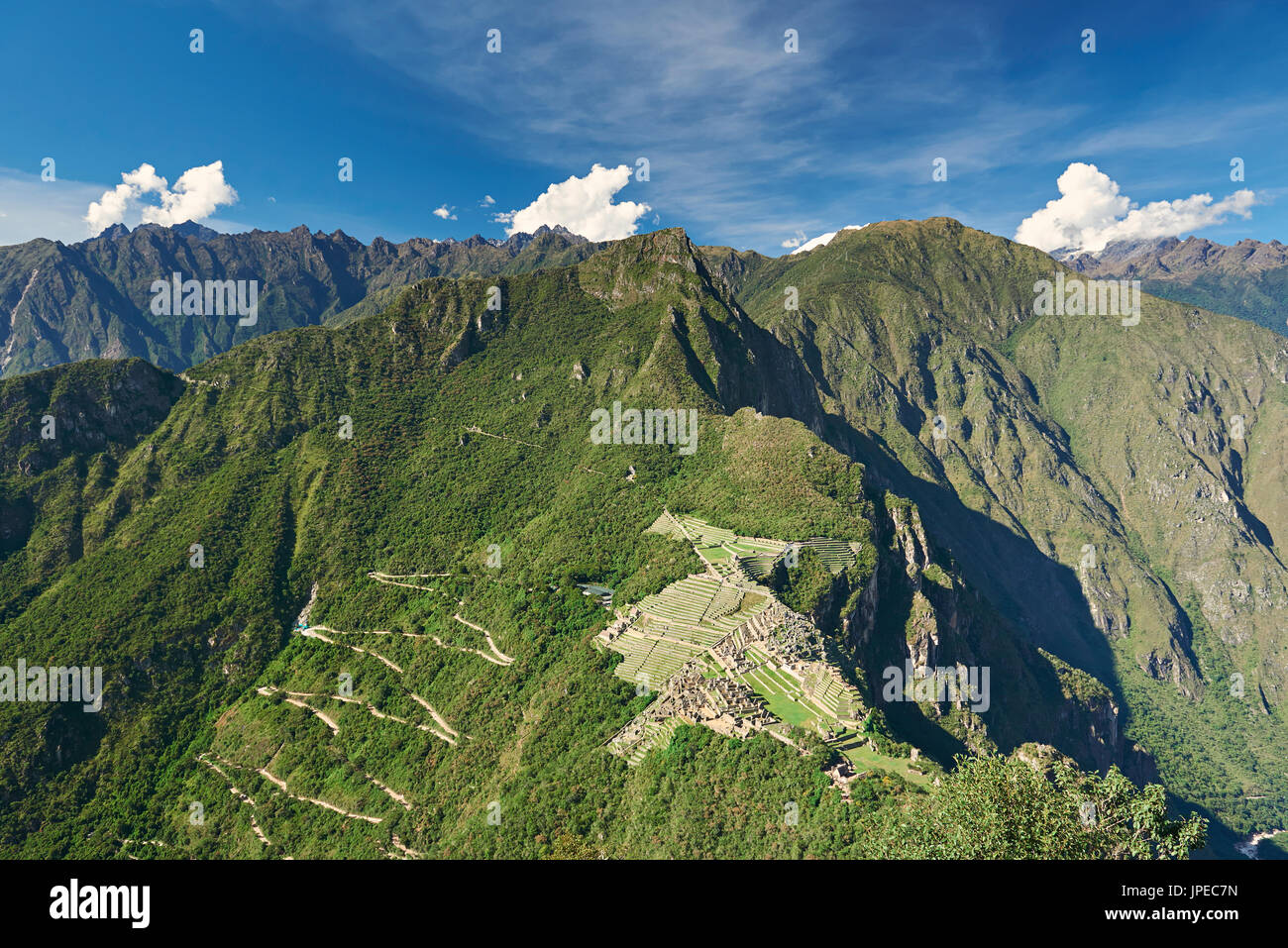 Machu Picchu-Stadt im grünen Berglandschaft unter blauem Himmel Stockfoto