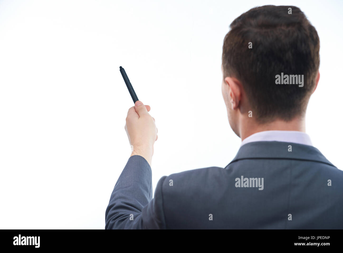 Lehrer mit Stift auf weißen Schreibtisch-Ansicht von hinten zeigt isoliert Stockfoto