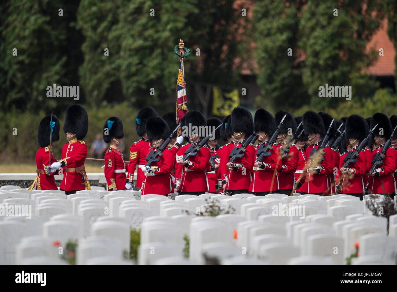 Britische Truppen nehmen Teil an den Veranstaltungen zum Gedenken für den Weltkrieg eine Schlacht von Passchendaele auf dem Tyne Cot-Friedhof in der Nähe von Ypern in Belgien. Das 1. Bataillon der Irish Guards marschieren durch die Grabsteine Stockfoto