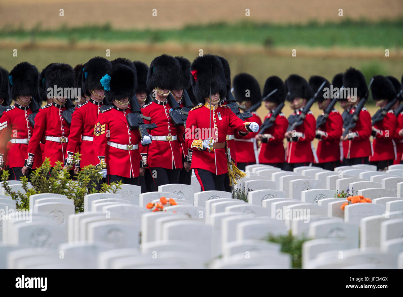 Britische Truppen nehmen Teil an den Veranstaltungen zum Gedenken für den Weltkrieg eine Schlacht von Passchendaele auf dem Tyne Cot-Friedhof in der Nähe von Ypern in Belgien. Das 1. Bataillon der Irish Guards marschieren durch die Grabsteine Stockfoto