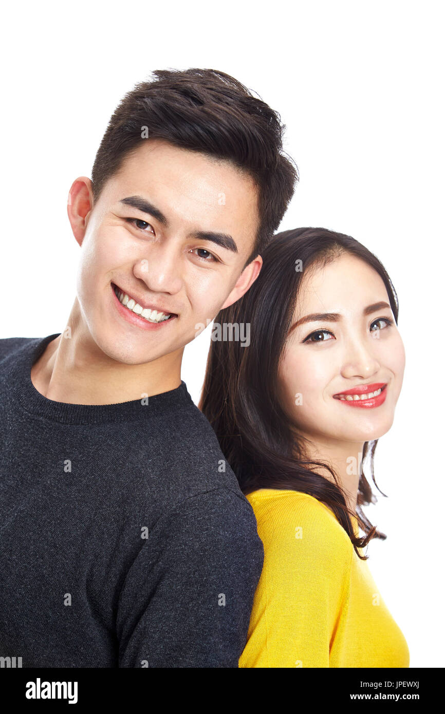 Studio-Porträt der jungen asiatischen paar Rücken an Rücken stehend Blick in die Kamera Lächeln, Kopfschuss, isoliert auf weißem Hintergrund. Stockfoto
