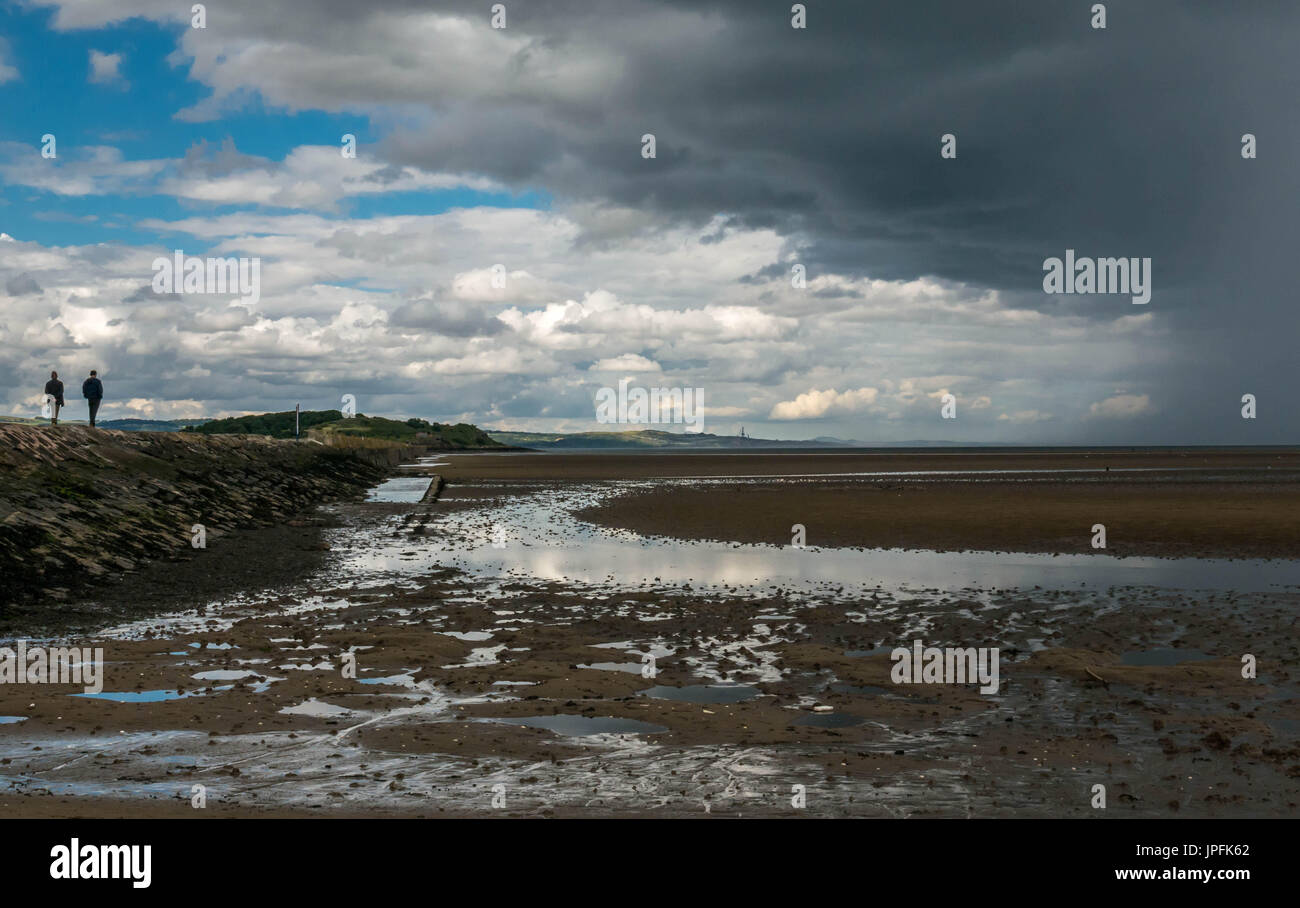 Sonnigem Sommerwetter und dramatischen dunkle Wolken mit intermittierender schweren Duschen über Firth von weiter tidal Causeway, Cramond, Edinburgh, Schottland, Großbritannien Stockfoto