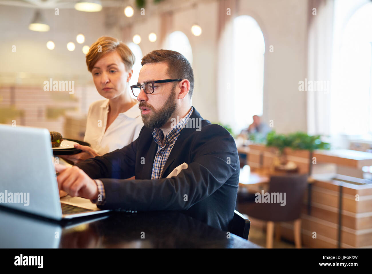 Besitzer des Restaurant, Kellnerin erklären, Änderungen im Online-Menü Stockfoto