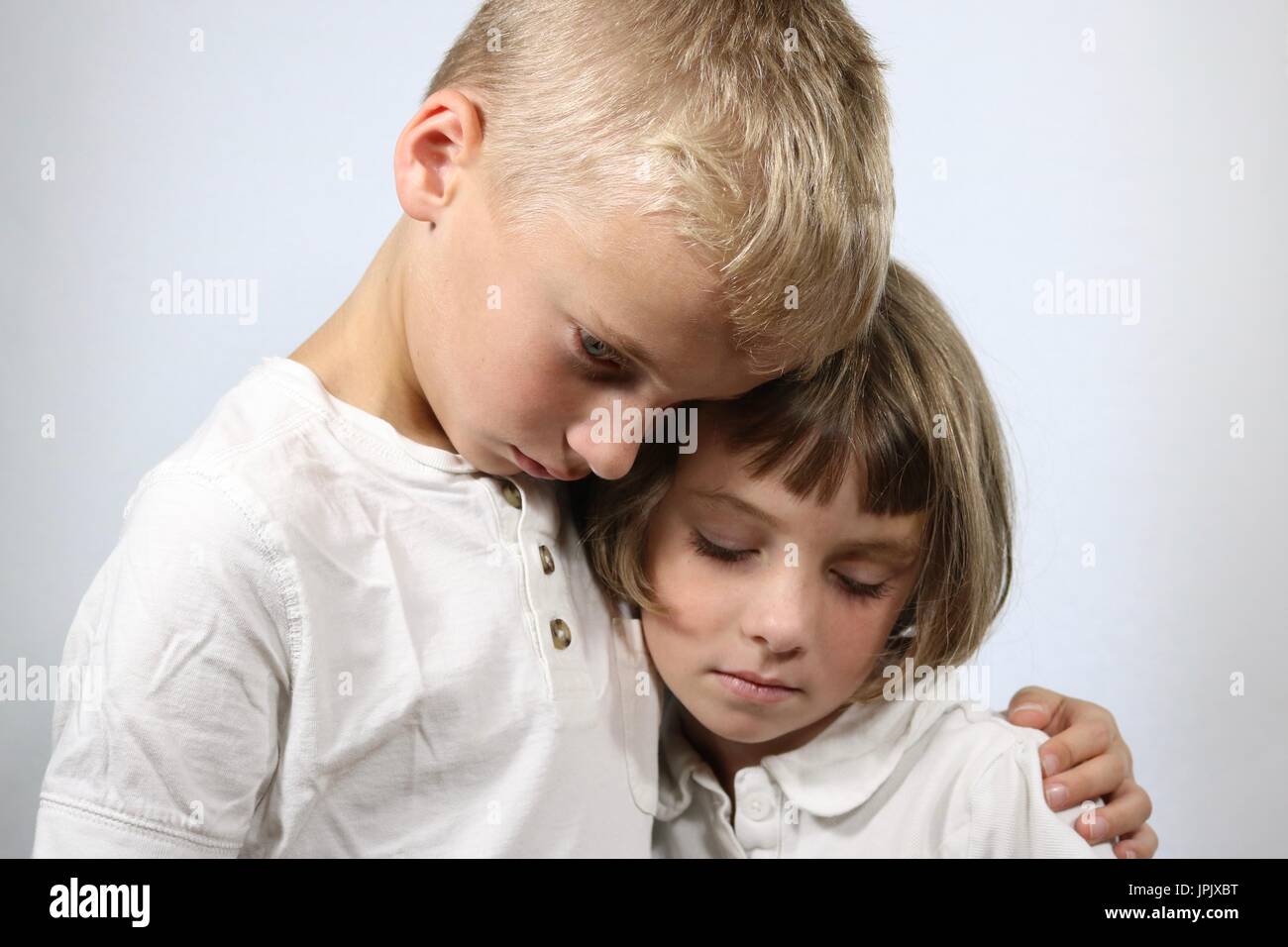 Portrait von trauernden Kindern in einer Umarmung Stockfoto