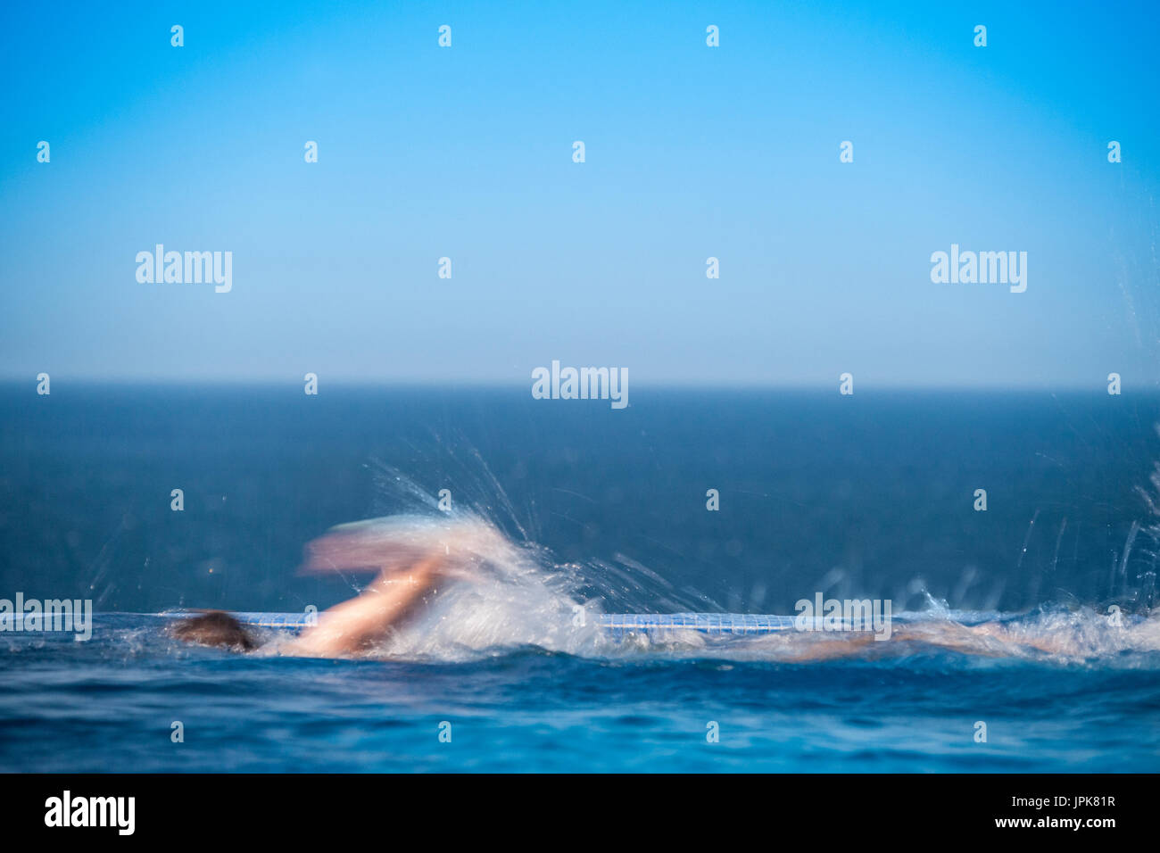 Ein Teenager trainiert in einen Infinity-Pool mit unscharfen Bewegungen Stockfoto