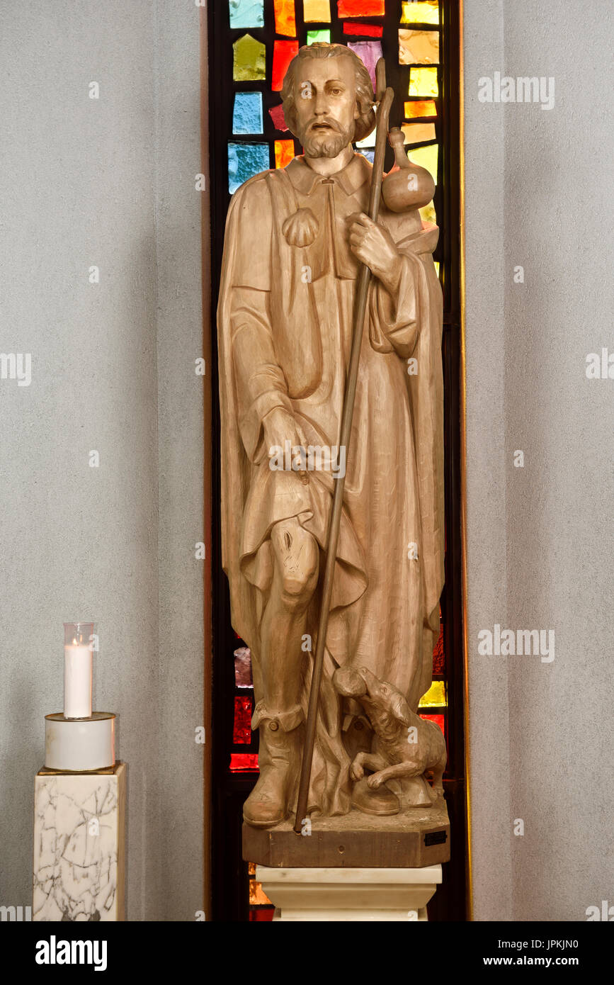 Holz geschnitzte Statue von Saint Roch mit Pest bubo auf den Oberschenkel und Hund mit Brot, die ihn in der Rede des Heiligen Rochus Katholische Kirche in Toronto Kanada gespeichert Stockfoto