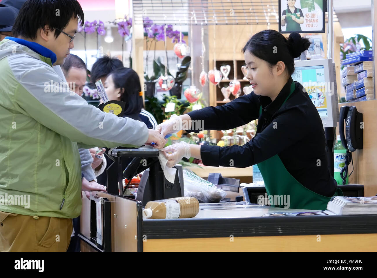 Menschen Sie Unterzeichnung Name für die Zahlung der Kreditkarte beim Check-out Schalter innen T & T Supermarkt Lebensmittel kaufen Stockfoto
