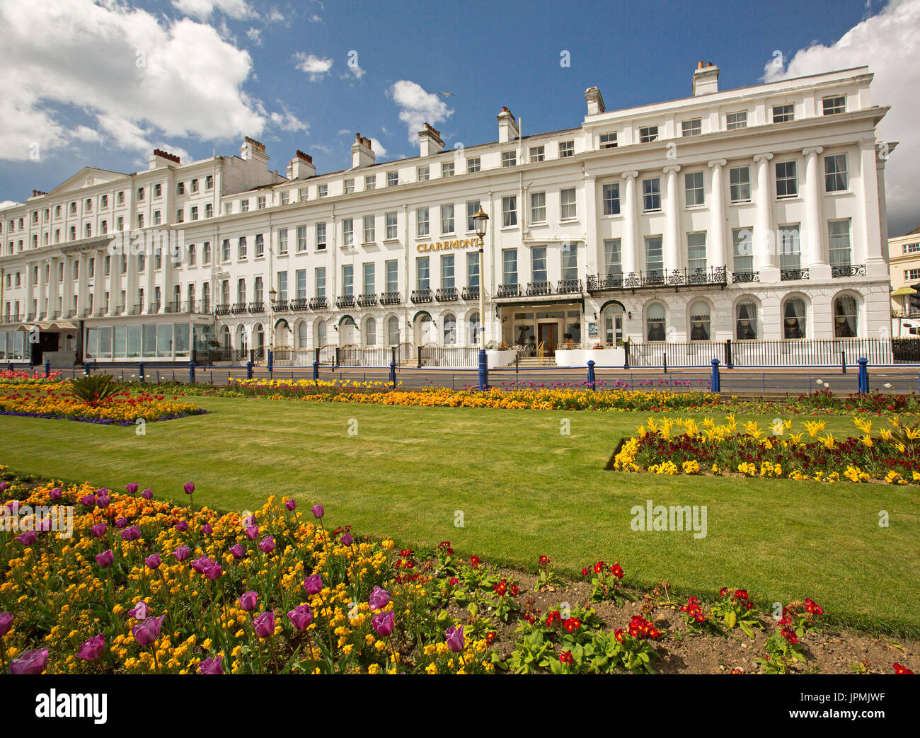 Große und imposante Claremont Hotel mit bunten Gärten von Tulpen im Vordergrund unter blauem Himmel in Eastbourne, England dominiert Stockfoto