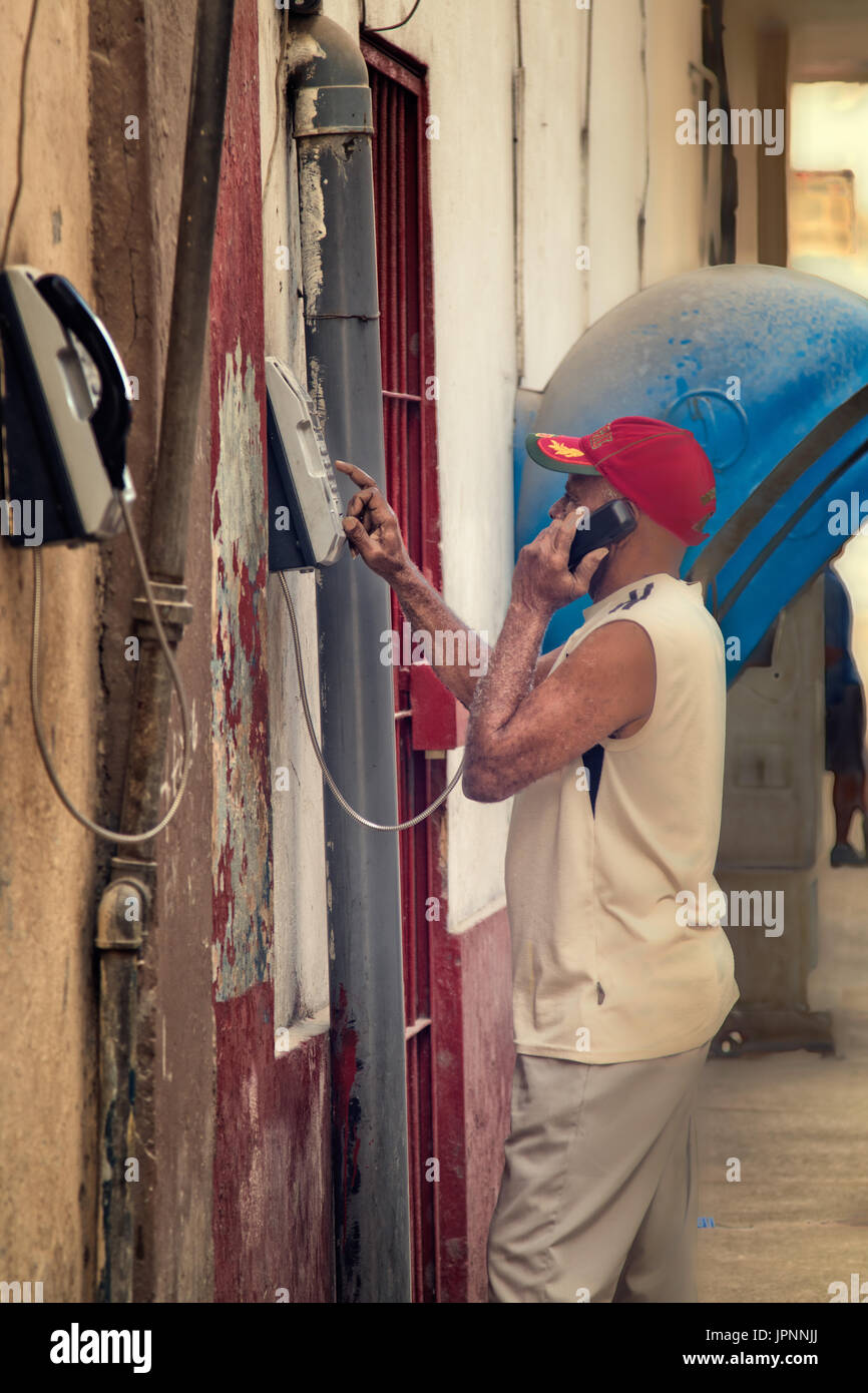 Ein kubanische Mann nutzt eine Gegensprechanlage, um wohnhaft in Mehrfamilienhaus in Havanna, Kuba zu kontaktieren. Stockfoto