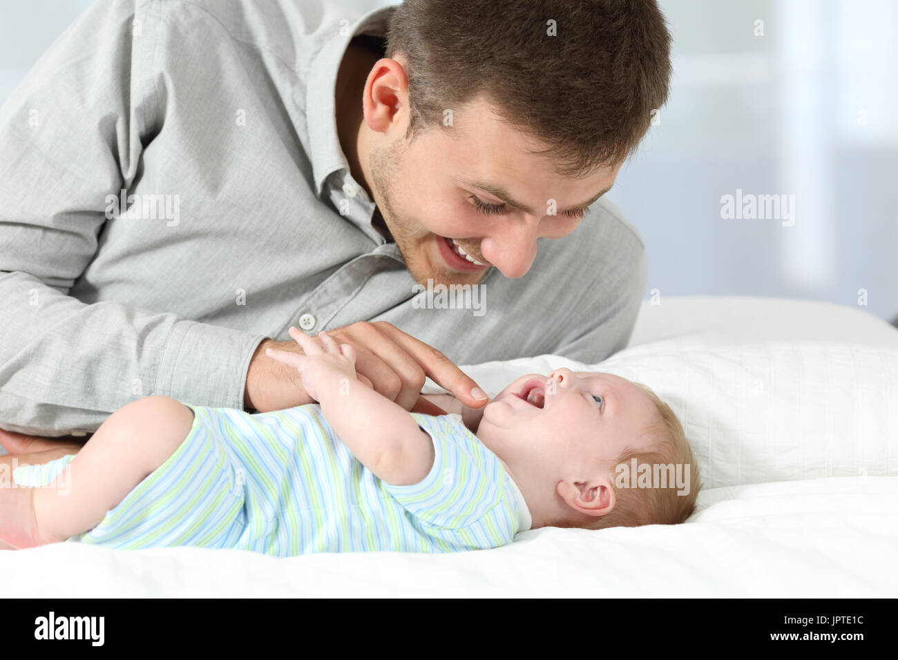 Porträt von glücklicher Vater spielt mit seinem Sohn auf einem Bett Stockfoto