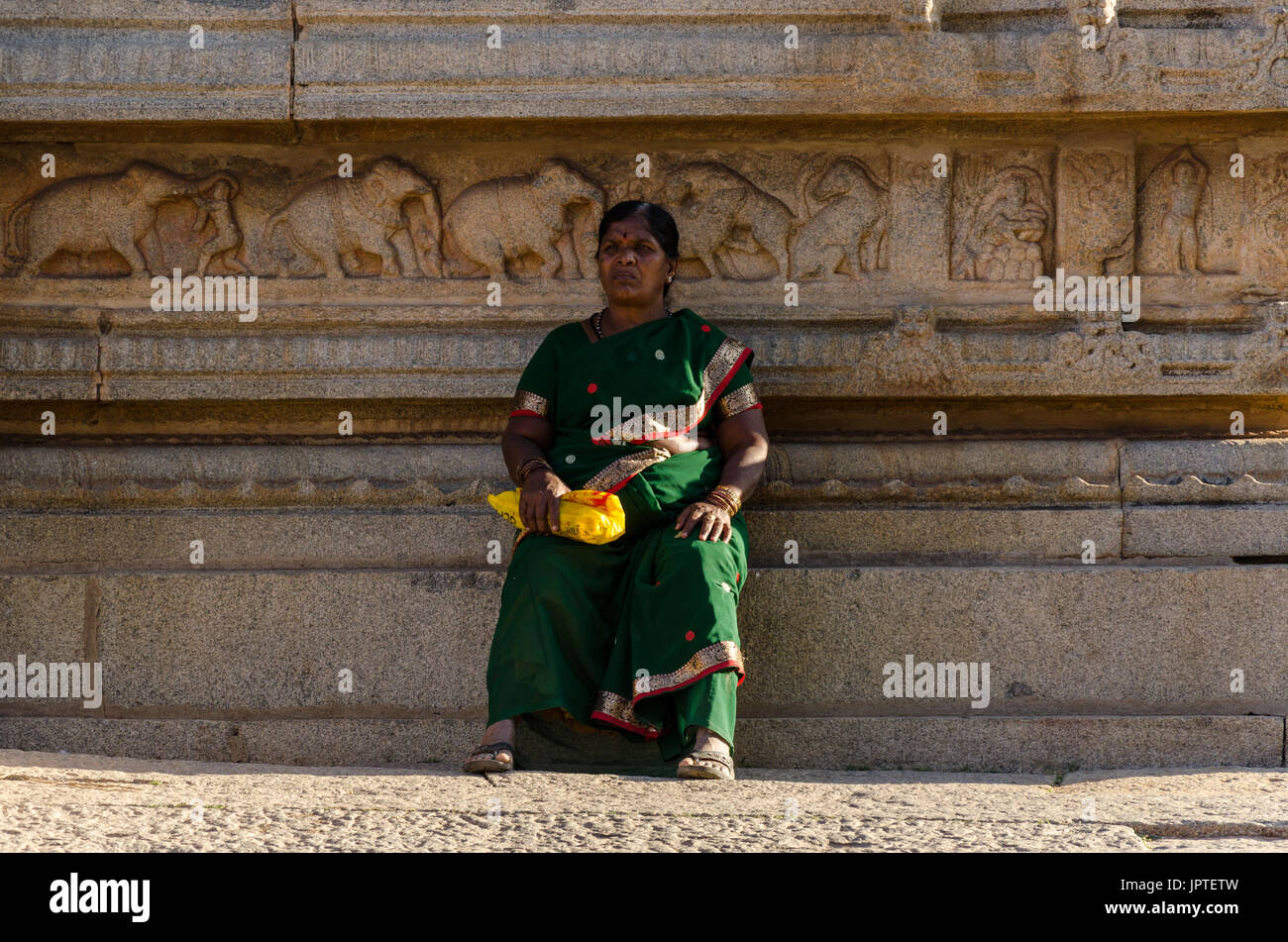 Eine Frau entspannt in den Vittala Tempel in Hampi, Karnataka, Indien Stockfoto