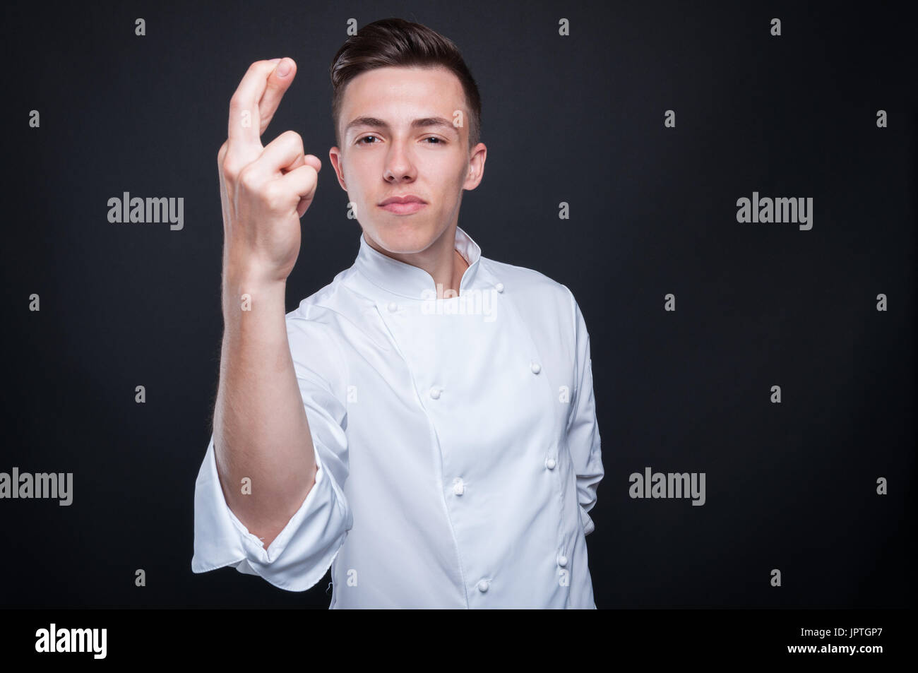 Männliche Cook posiert mit Daumen als Pech-Konzept auf dunklem Hintergrund mit Text-Raum Stockfoto