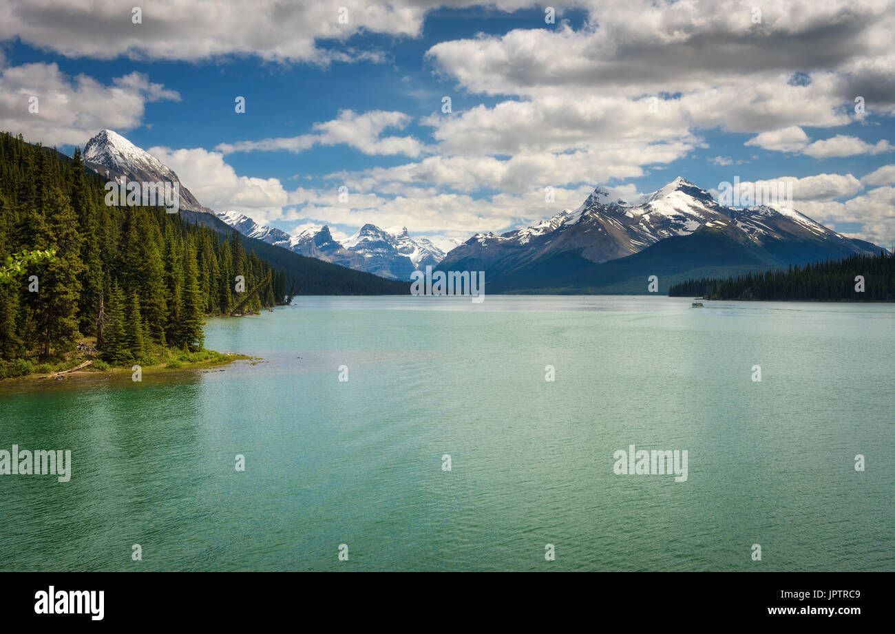 Idyllische Maligne Lake im Jasper Nationalpark, Kanada, mit Schnee bedeckten Gipfeln der kanadischen Rocky Mountains im Hintergrund. Stockfoto