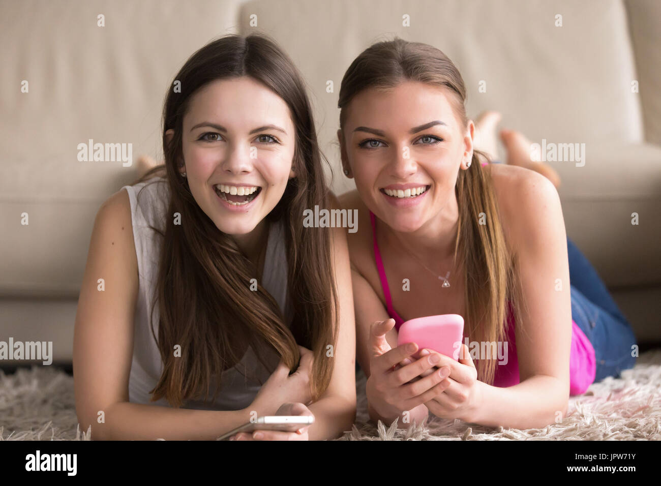 Zwei junge Frauen mit Handys Spaß online Stockfoto
