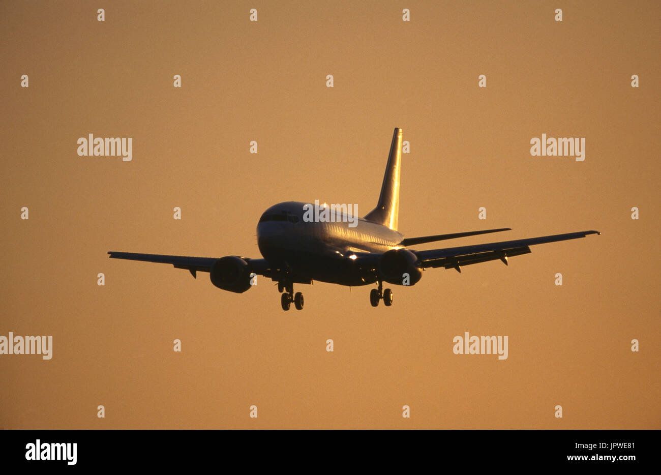 generische Boeing 737-300 auf Finale-Ansatz mit Klappen eingesetzt und Sonne glitzerte aus dem Rumpf und Leitwerk Stockfoto