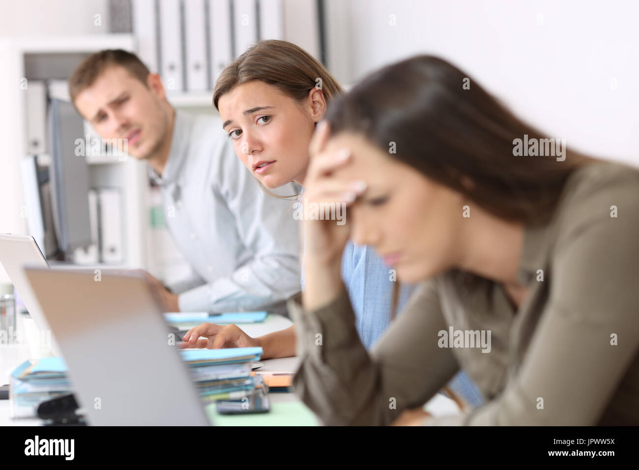 Traurig Arbeitnehmer betrachten ein frustriert Kollege, der schlechte Nachrichten auf Linie bei liest Stockfoto