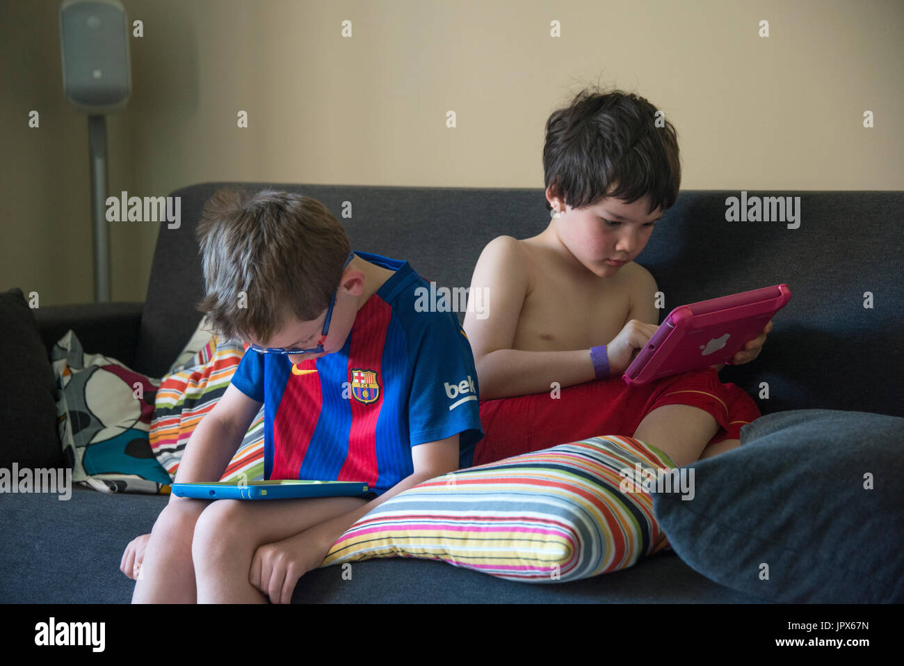 Zwei junge Jungen spielen auf iPads Stockfoto