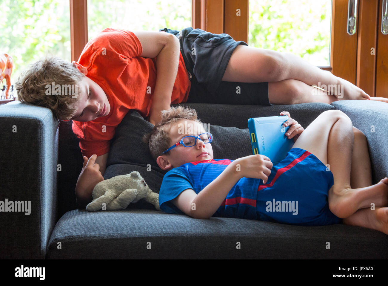 Young Boy spielen Computer-Spiel auf dem iPad mit anderen Jungen Ansehen Stockfoto