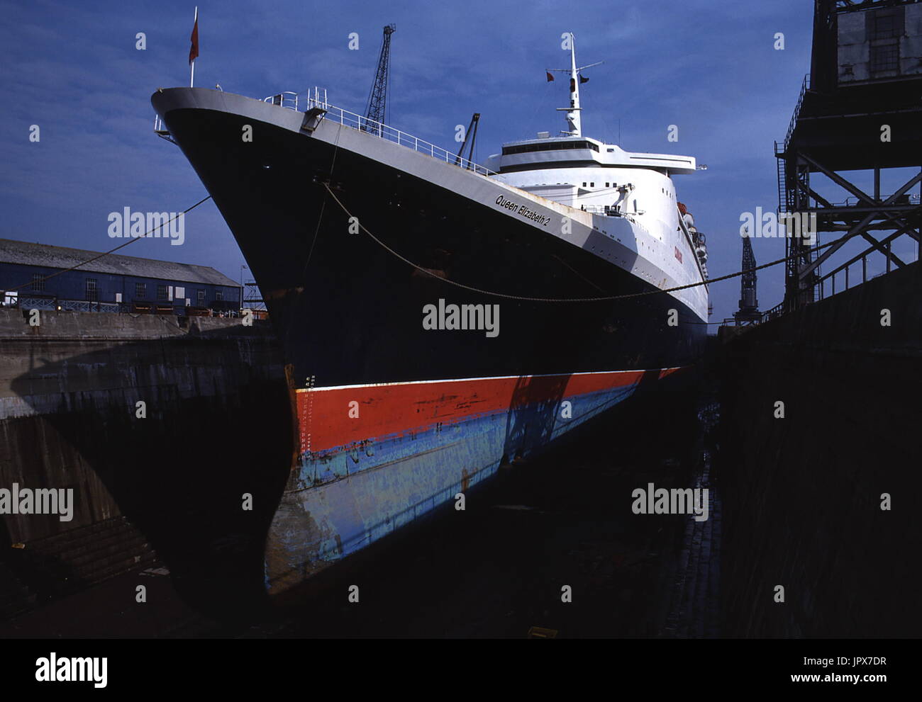 AJAXNETPHOTO. 21. JUNI 1982. SOUTHAMPTON, ENGLAND. -DER CUNARD LINER QE2 IN DER KING GEORGE V DRY DOCK WO DER LINER VON FALKLAND TRUPPENTRANSPORTER PASSAGIER PFLICHTEN RESTAURIERT WURDE.   FOTO: JONATHAN EASTLAND/AJAX.  REF: 910577 17 Stockfoto