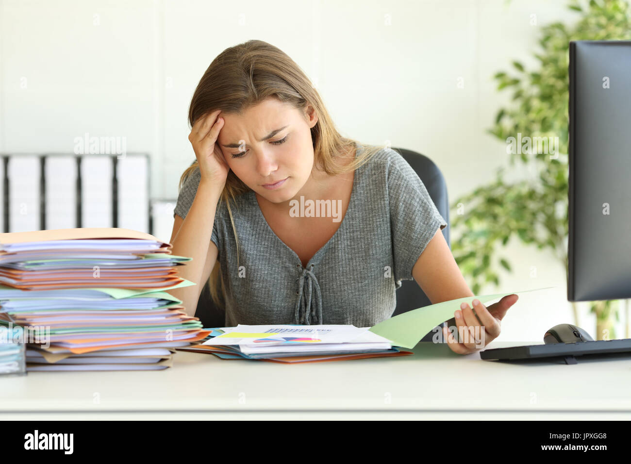 Vorderansicht Porträt eines besorgt Mitarbeiters schlechte Lektüre in ihrem Schreibtisch im Büro sitzen Stockfoto