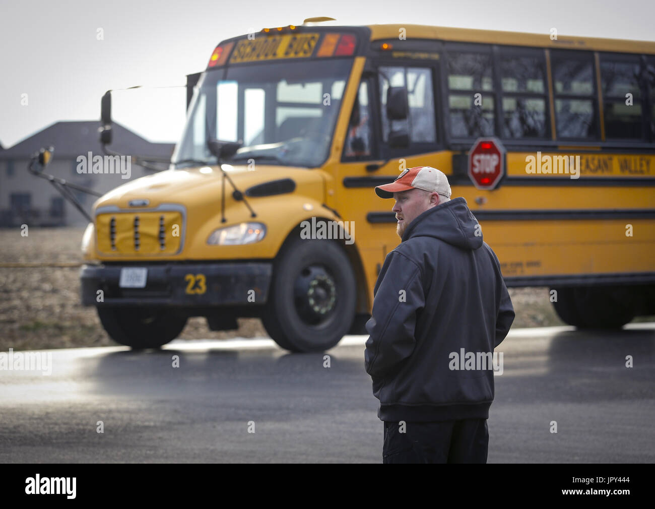 Bettendorf, Iowa, USA. 3. Januar 2017. Chris Prather von Bettendorf Uhren für den Verkehr während des Wartens auf seinen Sohn Travis, 8, aussteigen an der Kreuzung von Forest Grove Road und Nottingham Lane in ländlichen Bettendorf auf Dienstag, 3. Januar 2017. Eltern beschweren sich, dass die Schnittmenge ist zu gefährlich für jüngere Schüler werden immer aus dem Bus an und arbeiten für den Wandel zu Busse auf der Straße für einen sicheren Halt zu ziehen. Bildnachweis: Andy Abeyta/Quad-Stadt-Zeiten / ZUMA Draht/Alamy Live News Stockfoto