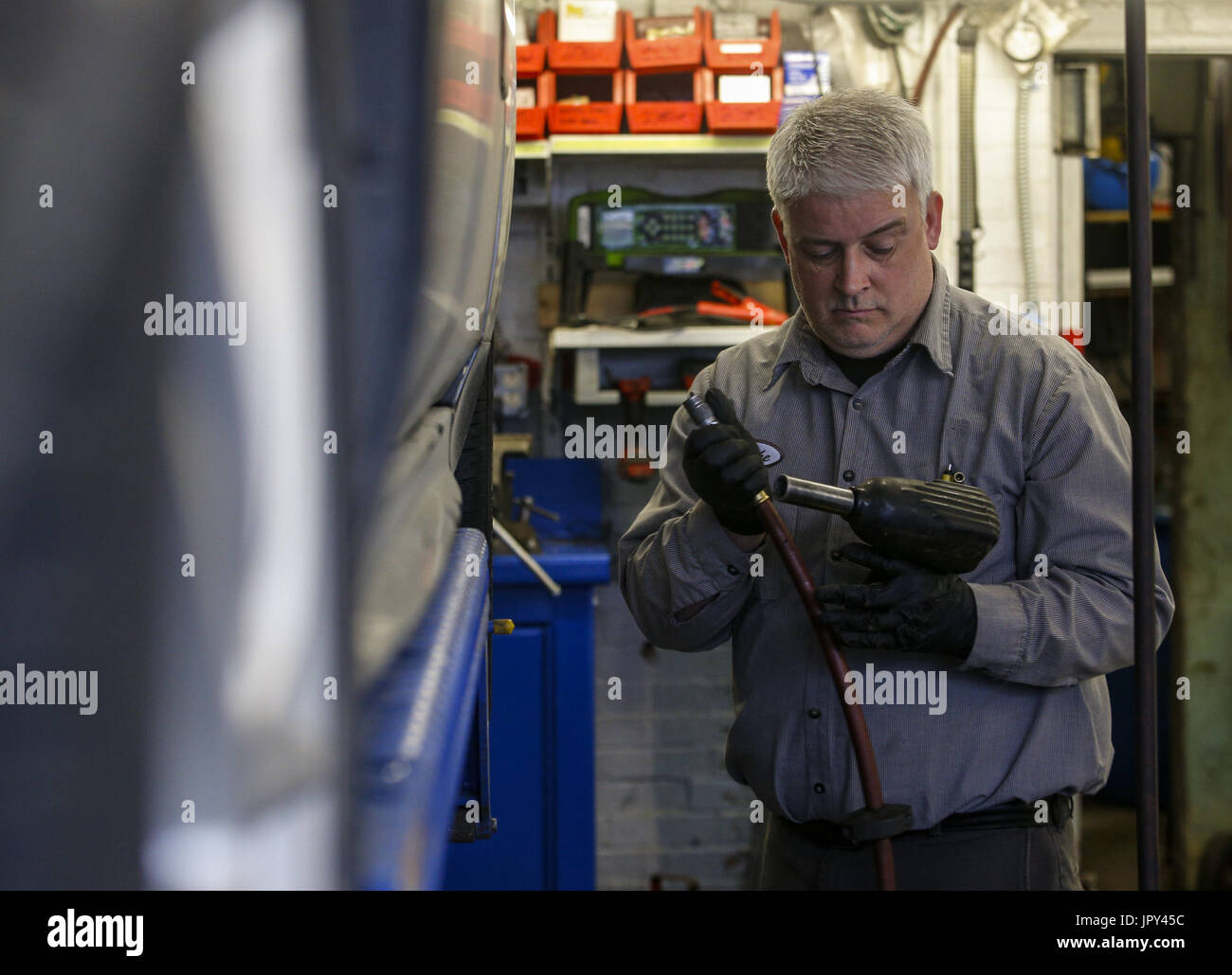 Davenport, Iowa, USA. 19. Januar 2017. Mechaniker Mike Waite bricht seine Auswirkungen Waffe nach dem Austausch der Bremsbeläge und Bremsscheiben auf ein Chevy Impala Dittmer Service in Davenport auf Donnerstag, 19. Januar 2017. Im Januar 2016 besaß die Familie Full-Service-Tankstelle trennten sich die Wege bei der Shell Oil Company. Die vier-Pumpstation verloren diese der großen Öl-Zugehörigkeit als Gebrüder Dittmer sich weigerte, den multinationalen Öl und Benzin Unternehmenserwartungen entsprechen. Bildnachweis: Andy Abeyta/Quad-Stadt-Zeiten / ZUMA Draht/Alamy Live News Stockfoto