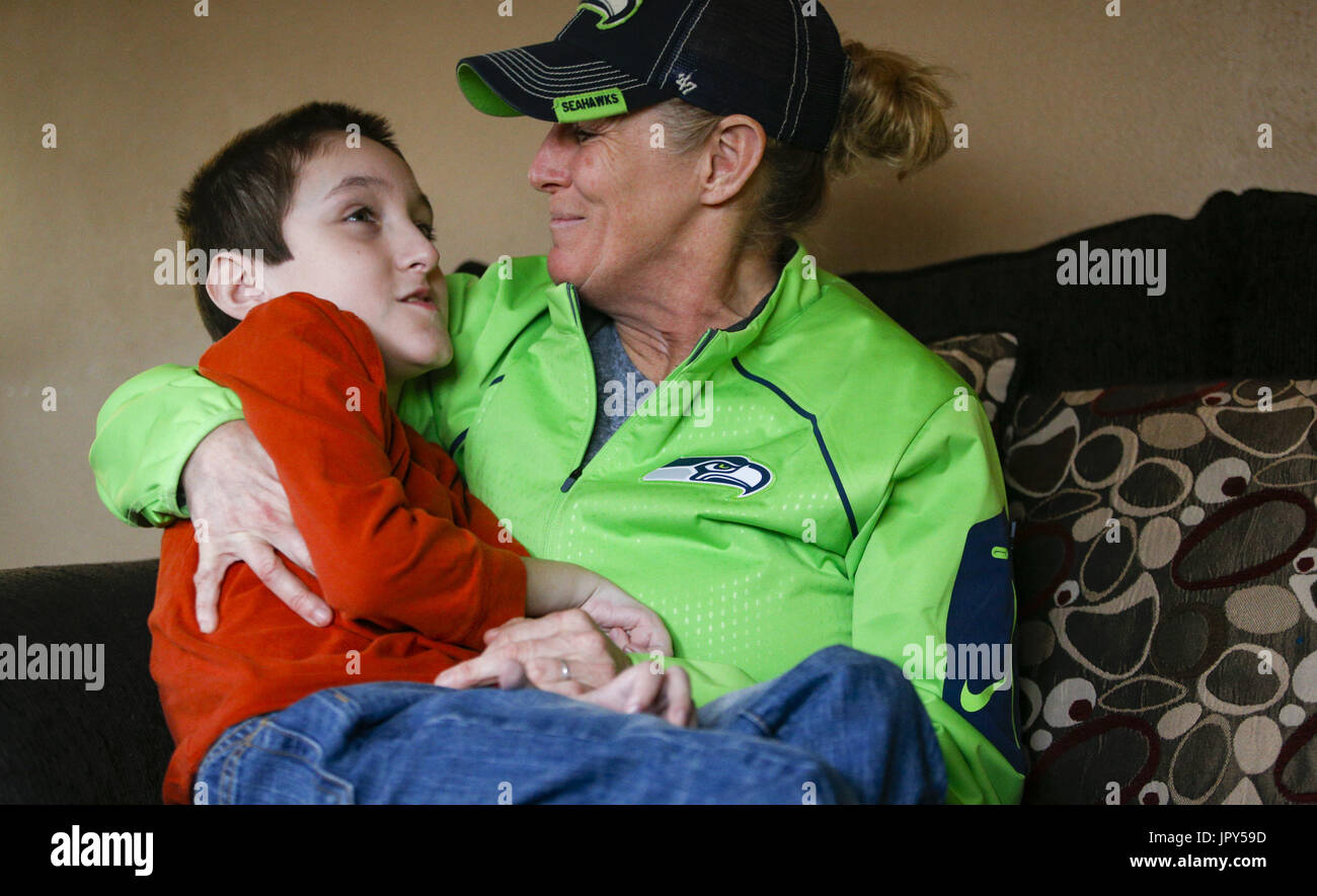 Davenport, Iowa, USA. 12. Januar 2017. Tina McDermott hält Sohn, Ryan, 10, zu Hause in Davenport auf Donnerstag, 12. Januar 2017 McDermott. McDermott war als Kleinkind mit Dravet-Syndrom, einer schweren Form von Epilepsie diagnostiziert und hat derzeit zwischen 10 und 20 Anfälle pro Tag. Eine Cannabis-Öl-Studie durch die Universität von Iowa funktionierte nicht für McDermott, aber er wird in Kürze eine Studie durch die Mayo-Klinik namens Fenfluramin Bewertung bei seltenen Epilepsie beginnen. Bildnachweis: Andy Abeyta/Quad-Stadt-Zeiten / ZUMA Draht/Alamy Live News Stockfoto