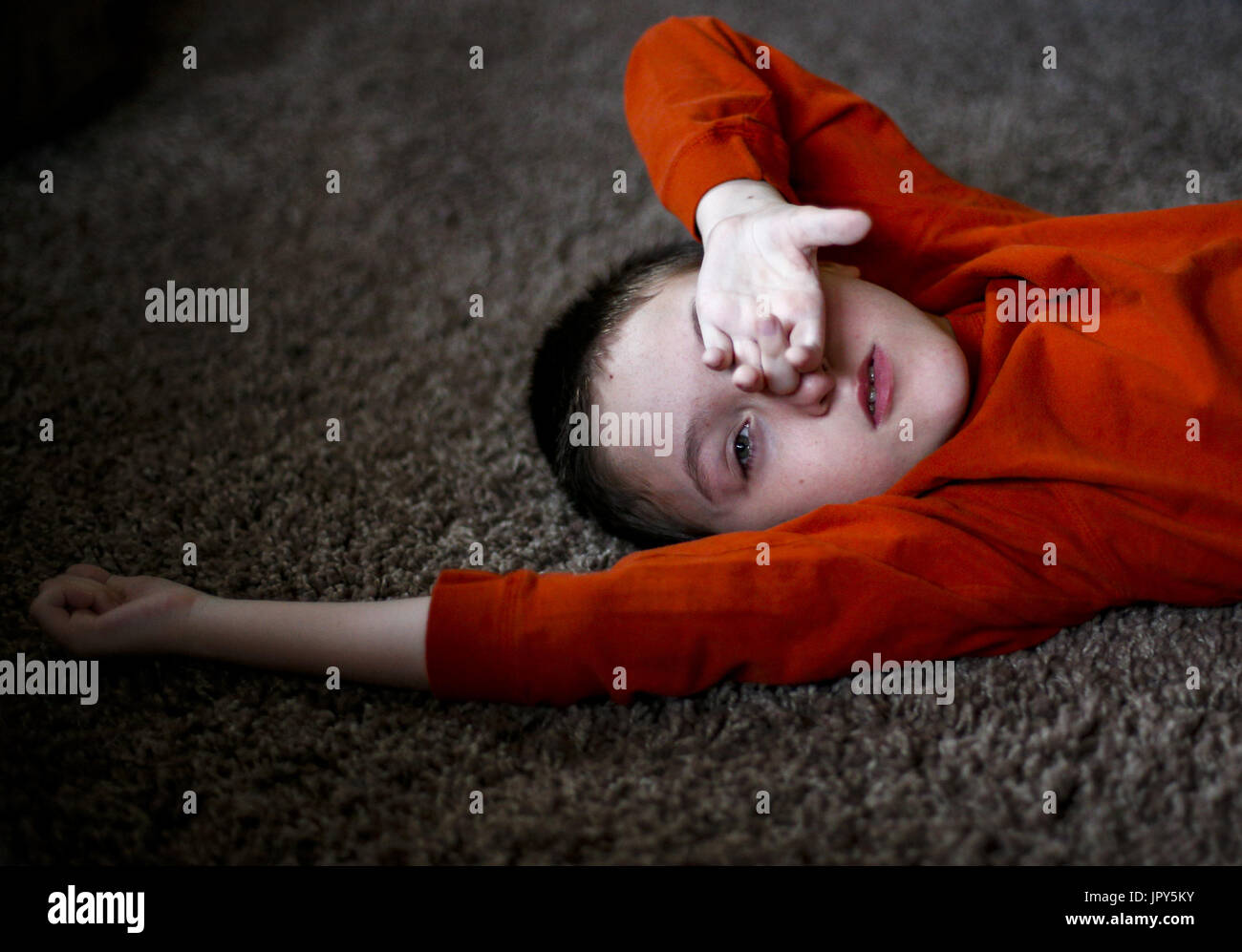 Davenport, Iowa, USA. 12. Januar 2017. Ryan McDermott, 10, legt auf den Boden zu Hause in Davenport McDermott auf Donnerstag, 12. Januar 2017. McDermott war als Kleinkind mit Dravet-Syndrom, einer schweren Form von Epilepsie diagnostiziert und hat derzeit zwischen 10 und 20 Anfälle pro Tag. Eine Cannabis-Öl-Studie durch die Universität von Iowa funktionierte nicht für McDermott, aber er wird in Kürze eine Studie durch die Mayo-Klinik namens Fenfluramin Bewertung bei seltenen Epilepsie beginnen. Bildnachweis: Andy Abeyta/Quad-Stadt-Zeiten / ZUMA Draht/Alamy Live News Stockfoto