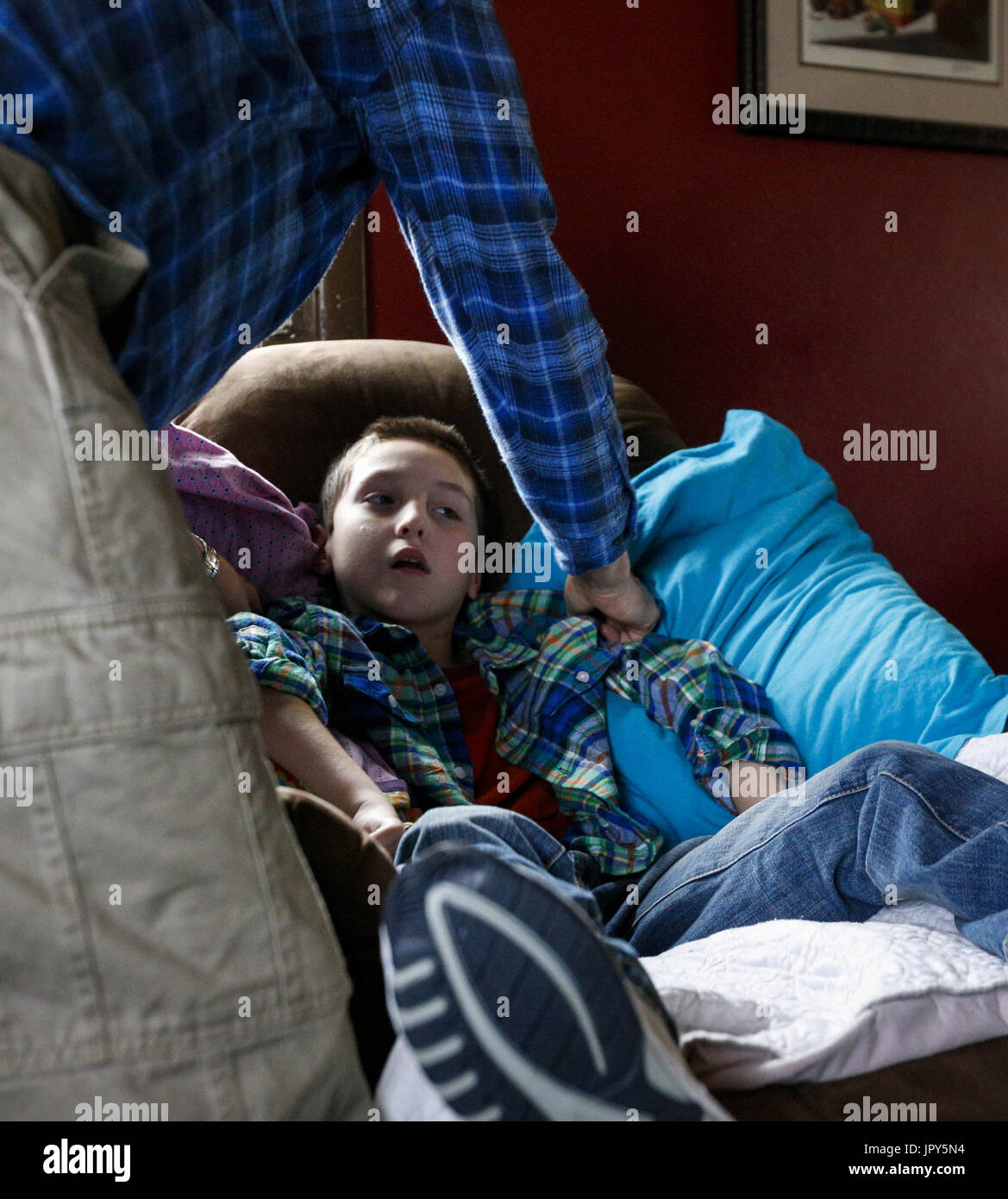 Davenport, Iowa, USA. 12. Januar 2017. Krankenschwester Randy Cox hilft Ryan McDermott, 10, in seinem Stuhl bequem zu Hause in Davenport McDermott auf Donnerstag, 12. Januar 2017 bekommen. McDermott war als Kleinkind mit Dravet-Syndrom, einer schweren Form von Epilepsie diagnostiziert und hat derzeit zwischen 10 und 20 Anfälle pro Tag. Eine Cannabis-Öl-Studie durch die Universität von Iowa funktionierte nicht für McDermott, aber er wird in Kürze eine Studie durch die Mayo-Klinik namens Fenfluramin Bewertung bei seltenen Epilepsie beginnen. Bildnachweis: Andy Abeyta/Quad-Stadt-Zeiten / ZUMA Draht/Alamy Live News Stockfoto