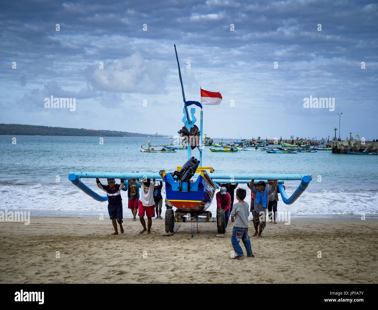 Kuta, Bali, Indonesien. 3. August 2017. Männer treiben ihre Ausleger Angeln Kanus auf Jimbrana Strand in Kuta nach einer durchzechten Nacht Angeln am Indischen Ozean. Der Strand liegt in der Nähe des Flughafens und eine kurze Autofahrt von den anderen Stränden im Südosten Bali. Jimbrana war ursprünglich ein Fischerdorf mit einem geschäftigen Markt. Vor etwa 25 Jahren Entwickler begann mit dem Bau von Restaurants und Hotels entlang der Strand und Land Preise steigen. Der neue Schwerpunkt auf Tourismus verändert sich die Natur der Gegend, aber die Fischer sind noch damit beschäftigt, in den sehr frühen Morgenstunden. Bildnachweis: Jack Kurtz/ZUMA Draht/Alamy Live-Nachrichten Stockfoto