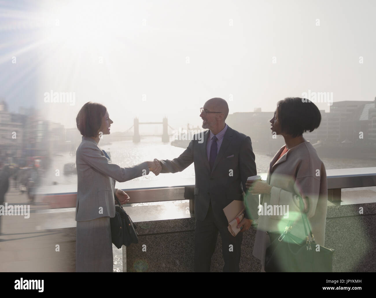 Silhouette Geschäft Leute Handshaking auf sonnigen städtische Brücke über der Themse, London, UK Stockfoto