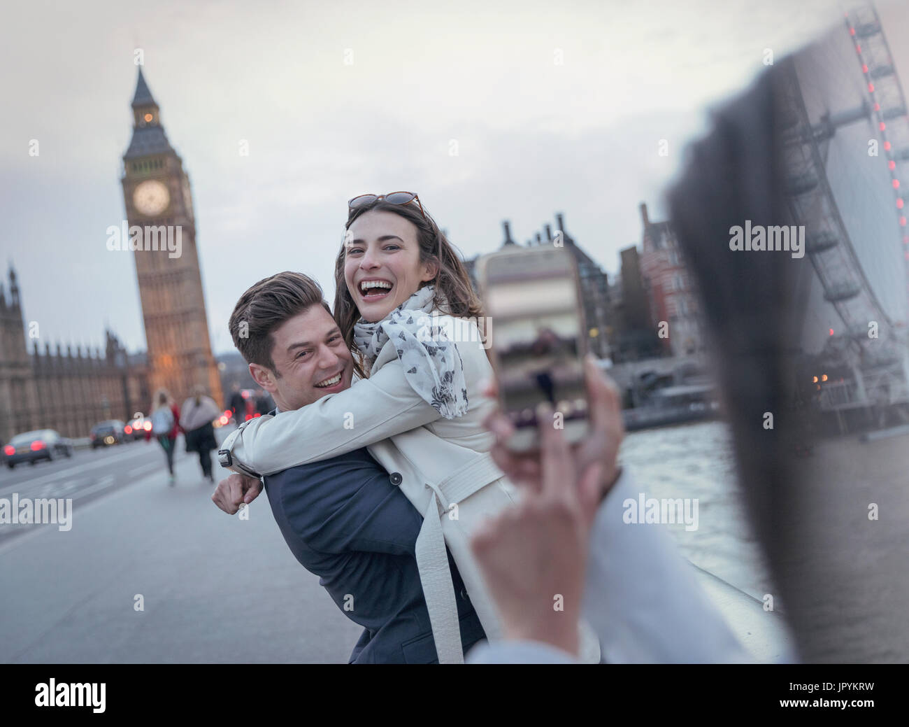 Verspieltes paar Touristen fotografierten auf Brücke in der Nähe von Big Ben, London, UK Stockfoto