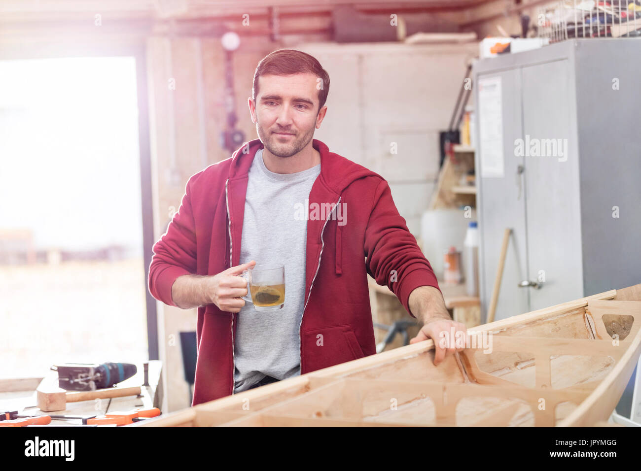Männliche Zimmermann, Tee zu trinken, so dass Holz-Boot in Werkstatt Stockfoto