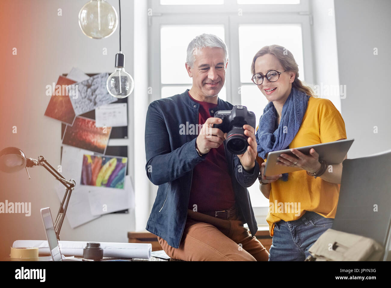 Fotografen, die mit digital-Tablette und eine Digitalkamera im Büro Stockfoto