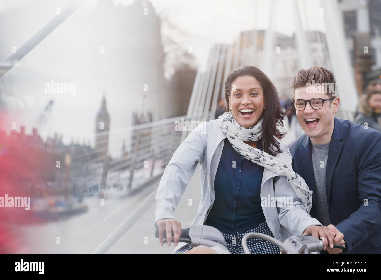 Porträt verspielte Paar Fahrrad fahren auf städtische Straße, London, UK Stockfoto