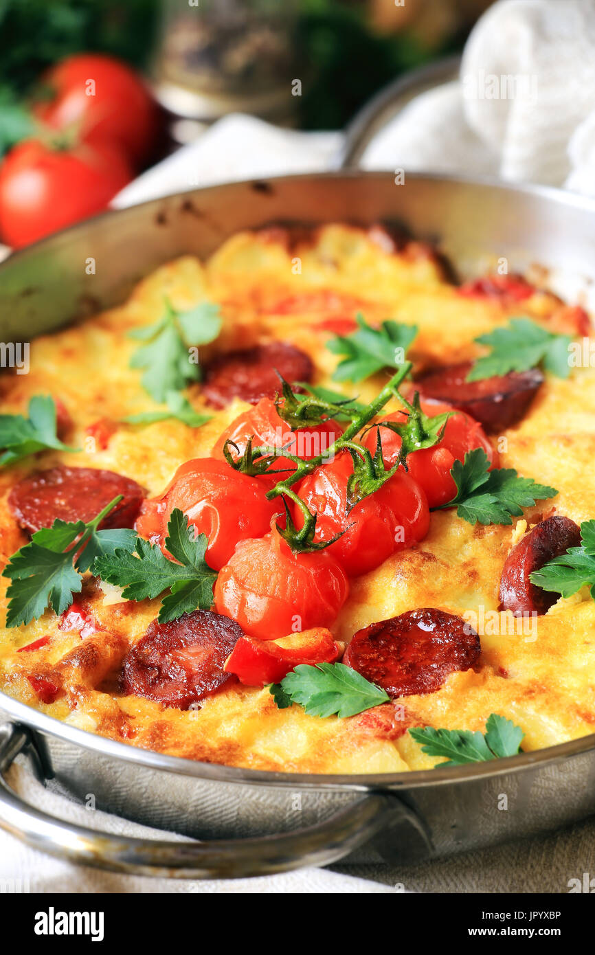 Spanisches Omelett - Tortilla de Patas mit Chorizo und Cherry-Tomaten auf einem Weinstock Stockfoto
