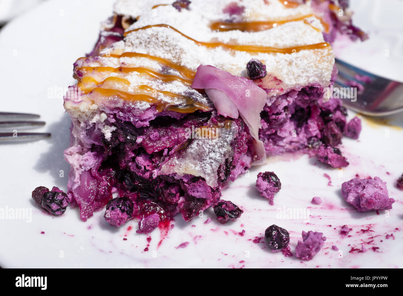 Blueberry Pie Strudel schließen Schuss auf weißen Teller, Kuchen mit zwei Gabeln teilweise im Hintergrund auf jeder Seite teilweise gegessen Stockfoto
