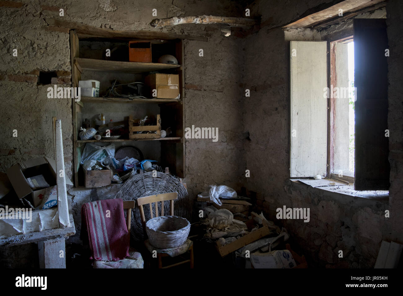 Zimmer von einer alten Hütte voller Krimskrams und erleuchtet durch ein Fenster Stockfoto
