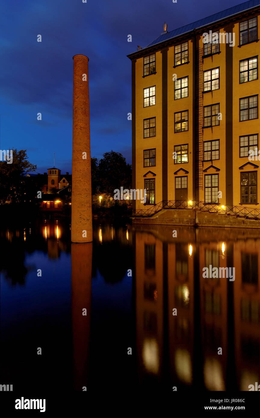 Blaue Stunde am Abend in Norrköping. Dies ist die alte Industrielandschaft und der Fluss Motala Ström verläuft in der Mitte zwischen einigen der Häuser. Stockfoto