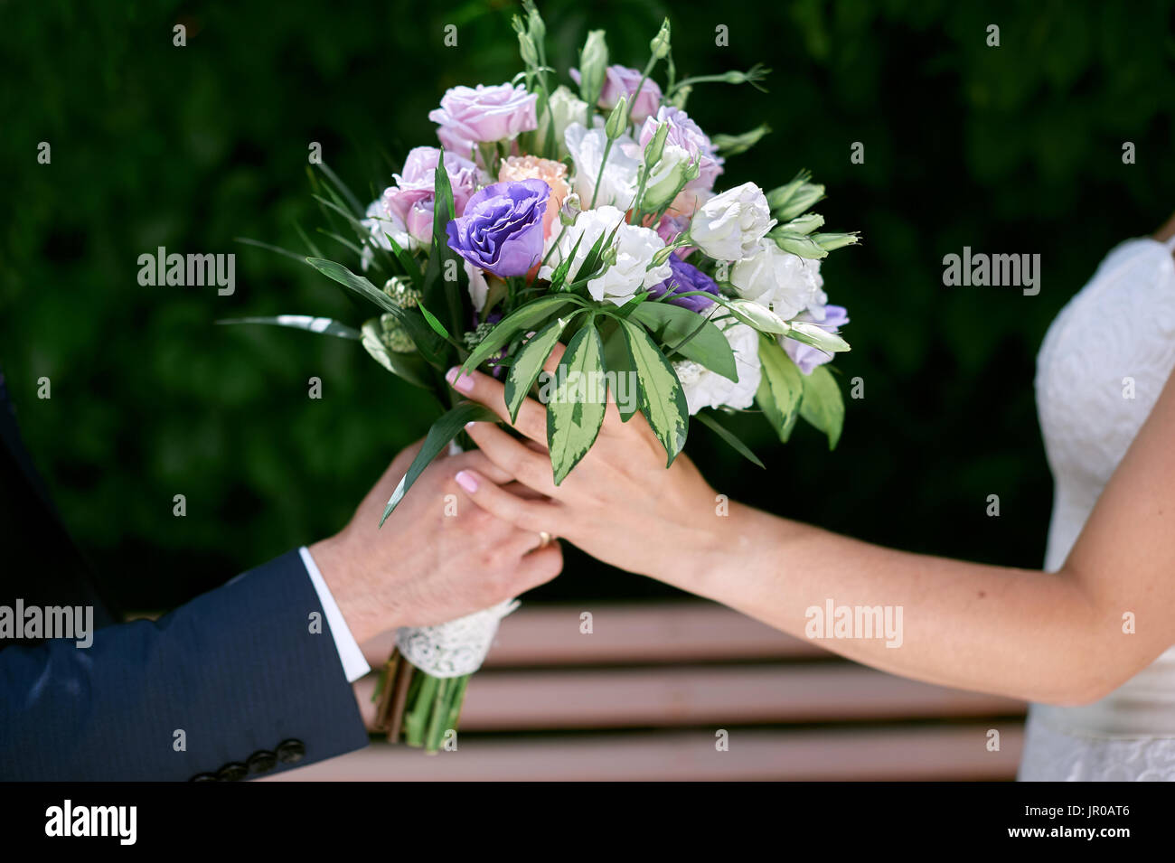 Bräutigam gibt der Braut einen Brautstrauß Stockfoto