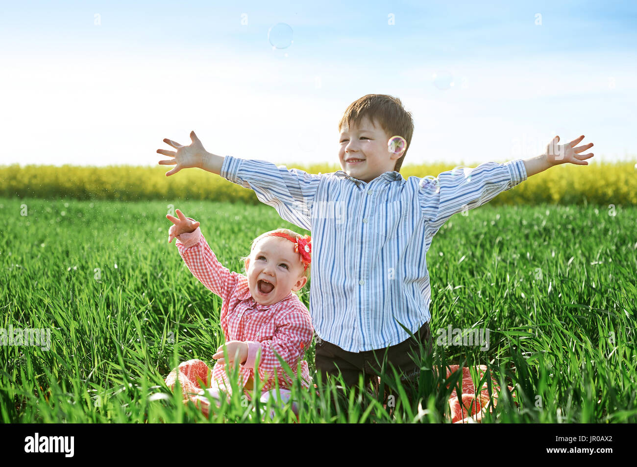 Kleine Kinder Jungen und Mädchen spielen auf dem grünen Rasen Stockfoto