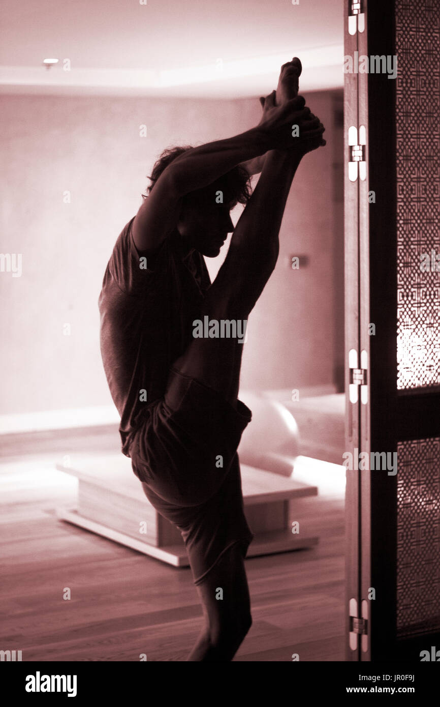 Männliche Yogalehrer tun teilt Bein Strecken Flexibilität Gymnastik und Yoga Asanapraxis im Fitness-Studio Stockfoto