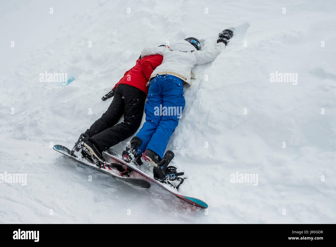 Zwei junge Snowboarder Festlegung gemeinsam Ruhen im Schnee, Whistler, British Columbia, Kanada Stockfoto