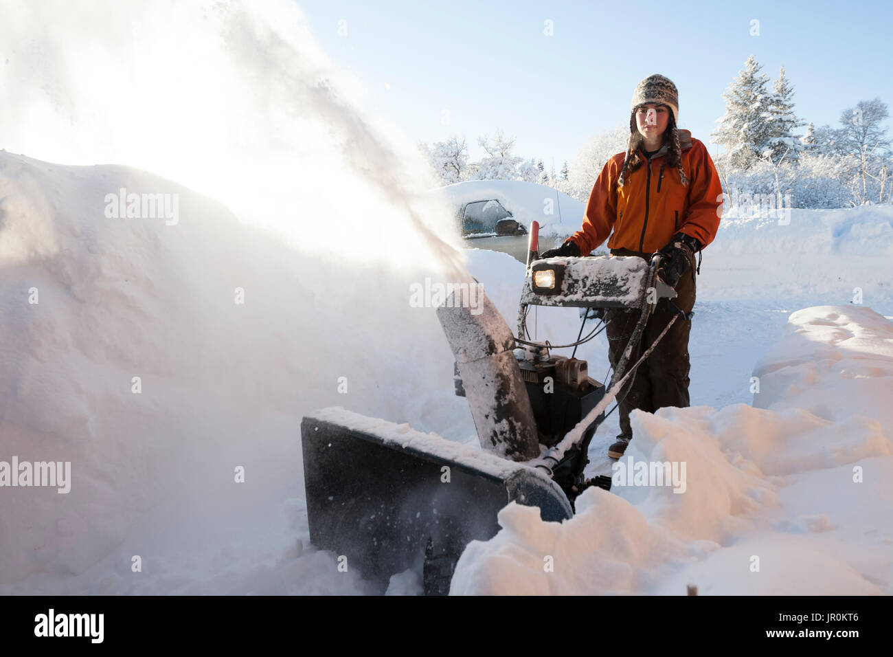 Eine junge Frau nutzt eine Schneefräse Im tiefen Schnee; Homer, Alaska, Vereinigte Staaten von Amerika Stockfoto