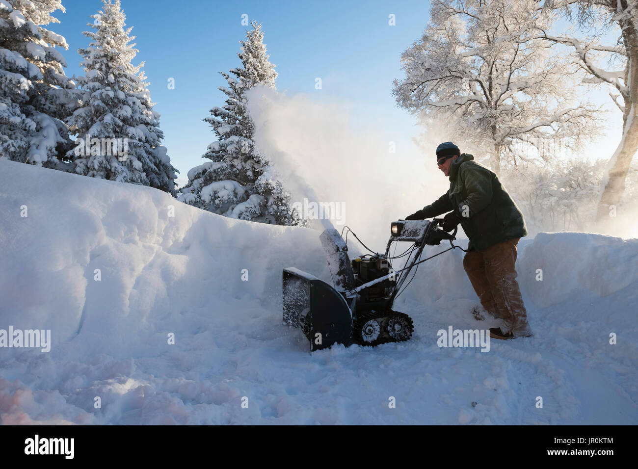 Ein Mann mit einer Schneefräse Im tiefen Schnee; Homer, Alaska, Vereinigte Staaten von Amerika Stockfoto