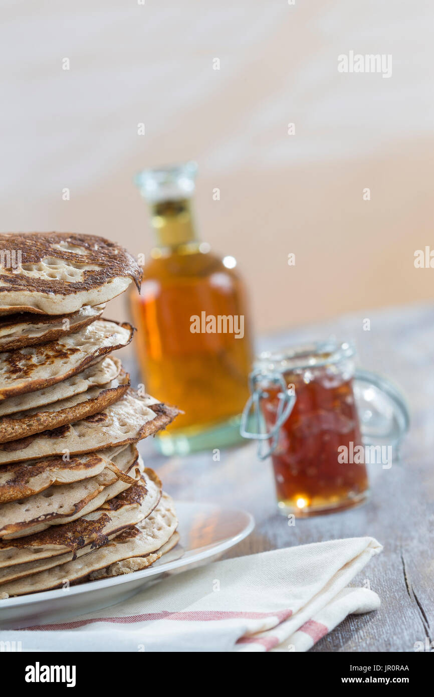 Saubere kostenlose Pfannkuchen mit Marmelade und Ahornsirup, gesunden Bio-Zutaten, auf weiß Stockfoto